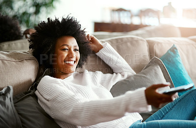 Buy stock photo Black woman, watching tv and relax on sofa with remote, smile and happiness for film, comedy or show. African girl, television and happy for movie, video and browsing on lounge couch in apartment