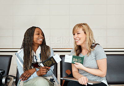 Buy stock photo Cropped shot of two young girlfriends chatting while waiting in the departure lounge of an airport
