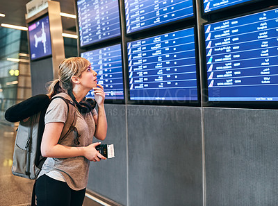 Buy stock photo Cropped shot of an attractive young woman looking at the flight schedule in an airport