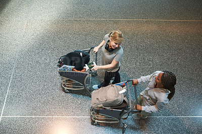 Buy stock photo High angle shot of two attractive young women walking through an airport