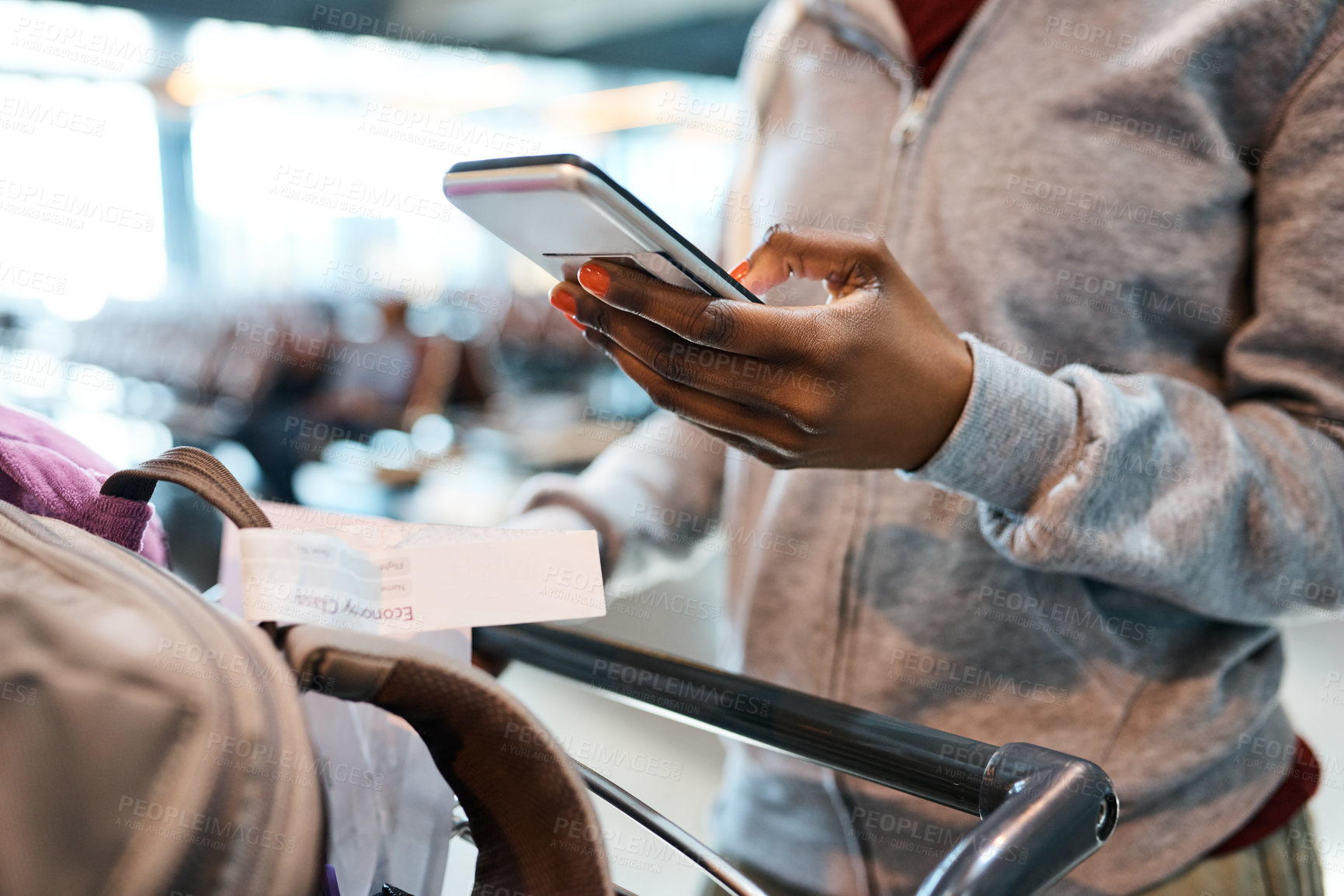 Buy stock photo Cropped shot of an unrecognizable woman sending a text while standing in an airport