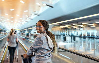 Buy stock photo Rearview portrait of an attractive young woman walking through an airport