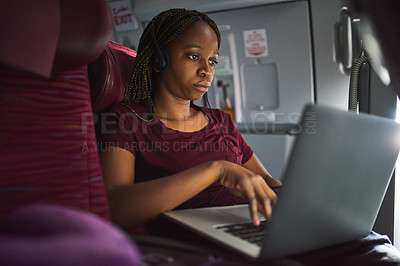 Buy stock photo Cropped shot of an attractive young woman using her laptop while sitting on a plane