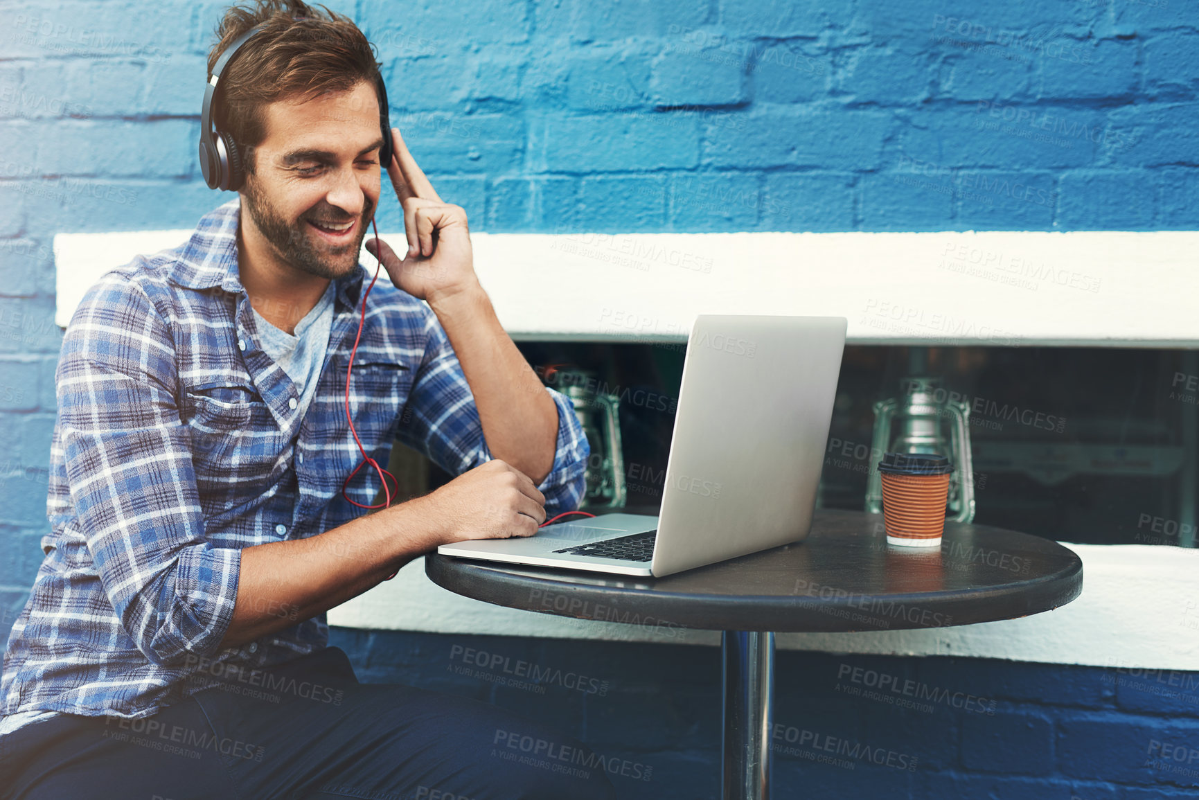 Buy stock photo Headphones, music and happy man on laptop at cafe for remote work, sound or streaming radio at table. Computer, audio and freelancer in coffee shop for social media, podcast and listening to jazz