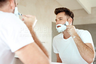 Buy stock photo Cropped shot of a handsome young man going through his morning routine in the bathroom