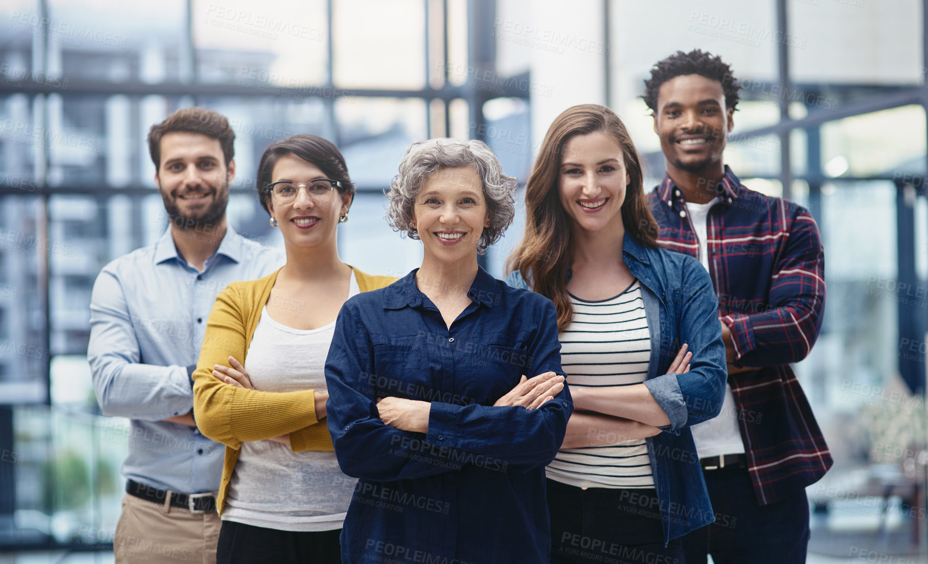 Buy stock photo Portrait of a group of creatives standing with their arms folded in an office