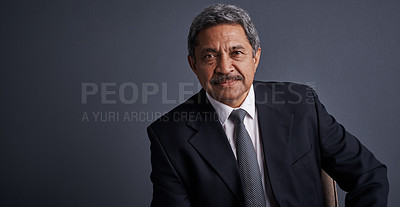 Buy stock photo Studio shot of a mature businessman posing against a dark background 