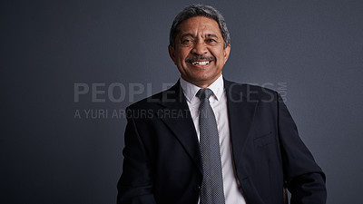 Buy stock photo Studio shot of a mature businessman posing against a dark background 