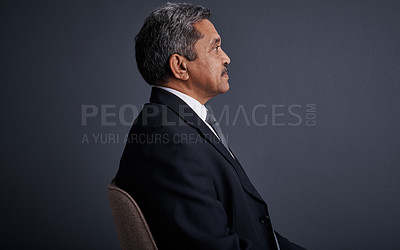Buy stock photo Studio shot of a mature businessman posing against a dark background 