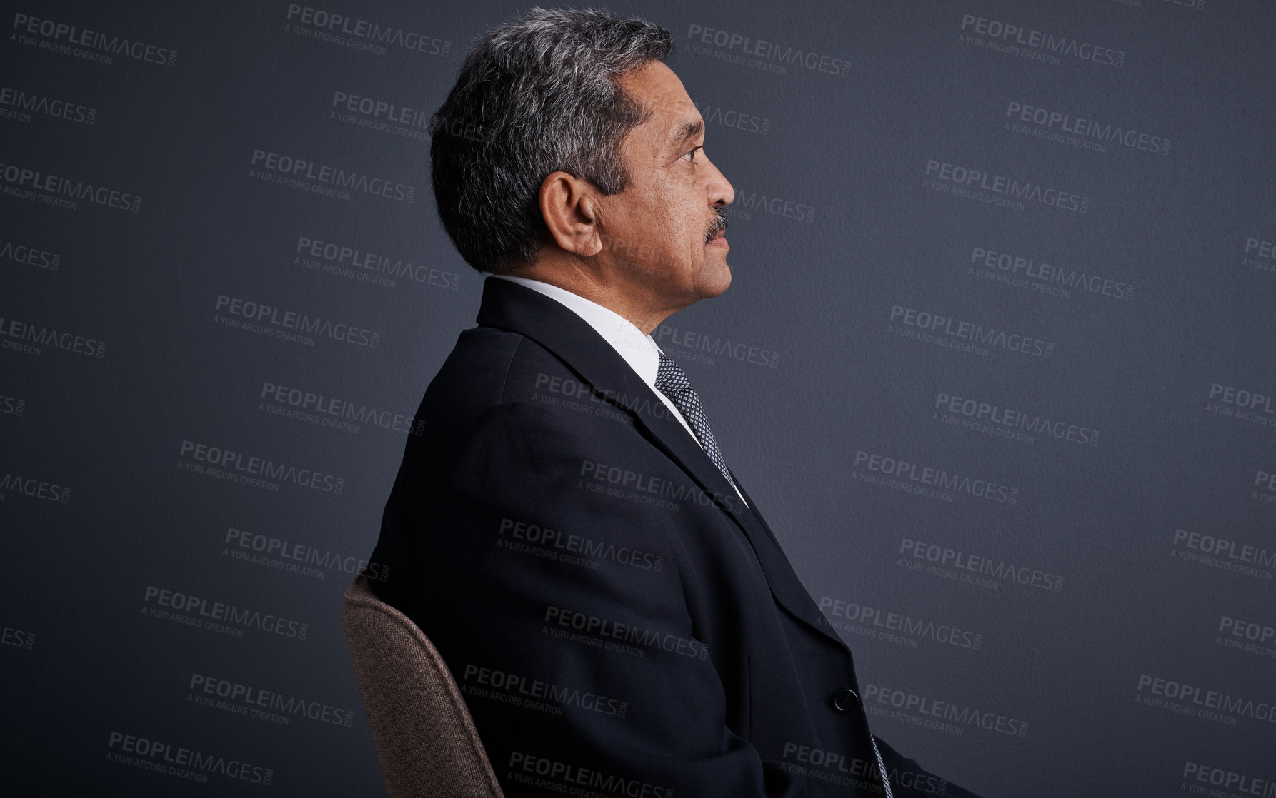 Buy stock photo Studio shot of a mature businessman posing against a dark background 