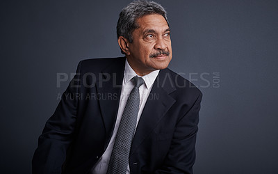 Buy stock photo Studio shot of a mature businessman posing against a dark background 