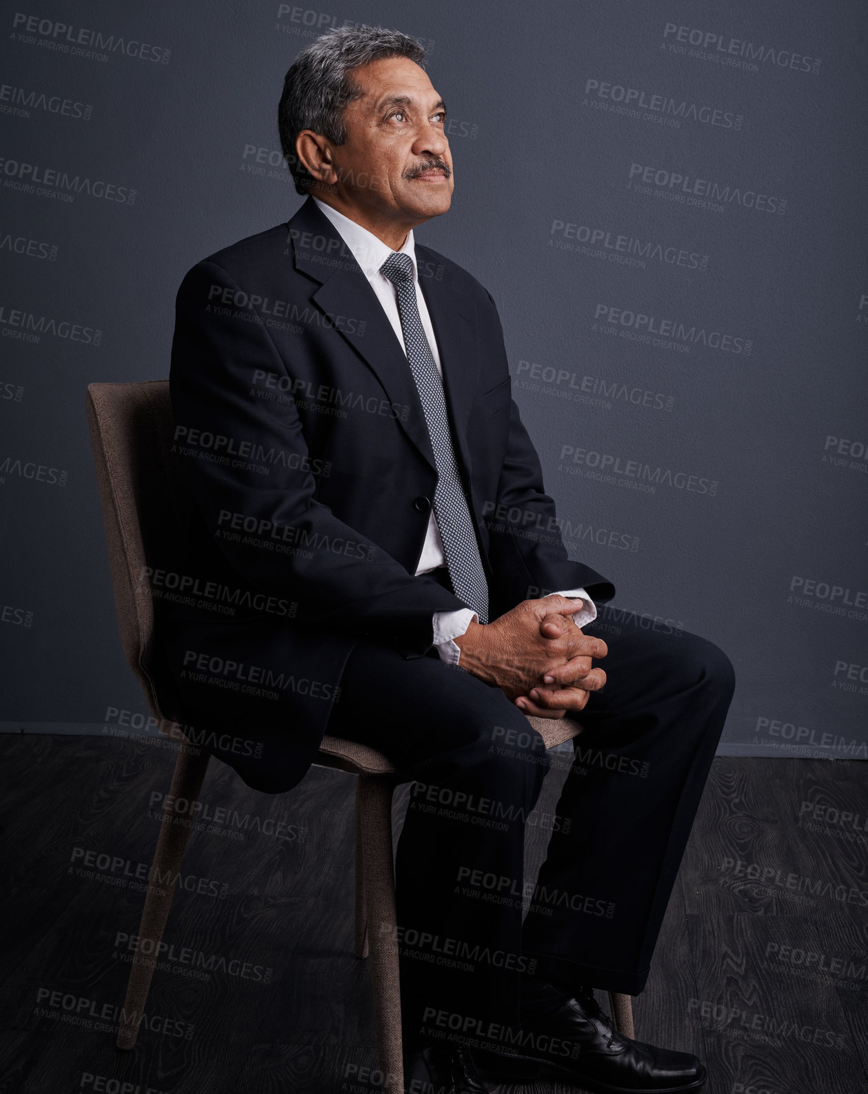 Buy stock photo Studio shot of a mature businessman posing against a dark background 