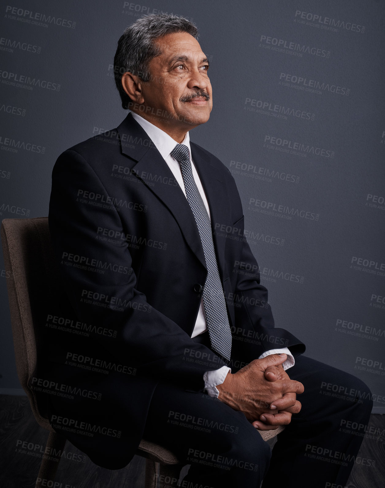 Buy stock photo Studio shot of a mature businessman posing against a dark background 