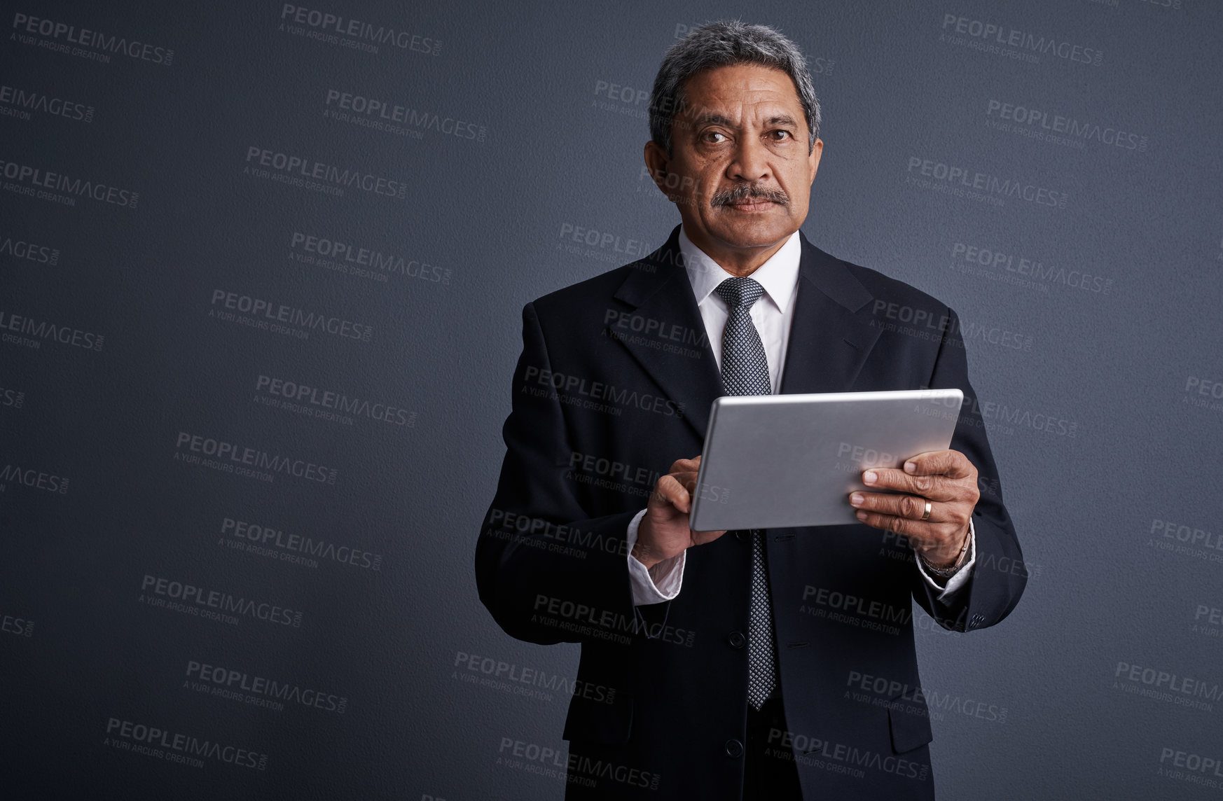 Buy stock photo Studio shot of a mature businessman using his digital tablet