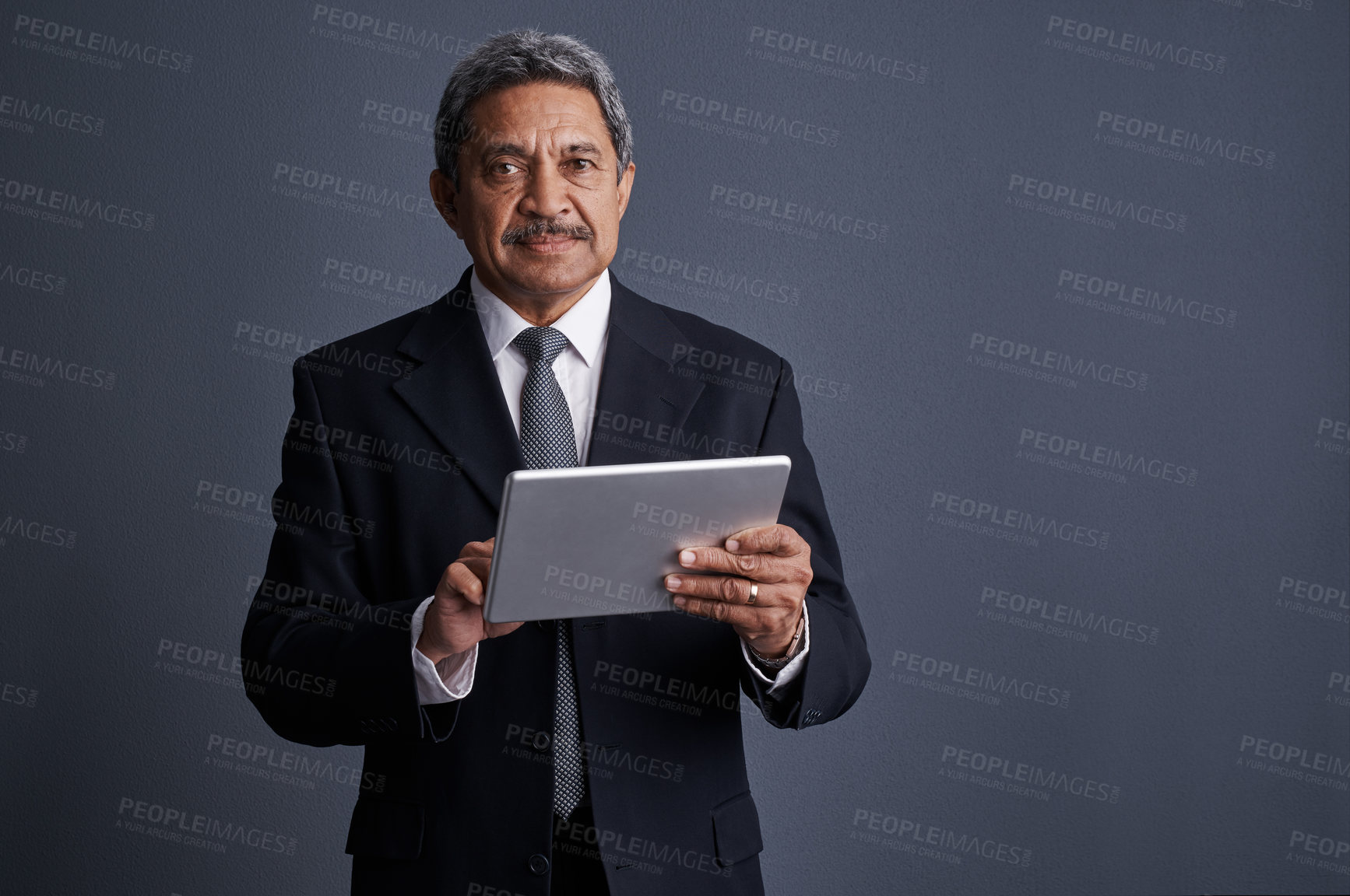 Buy stock photo Studio shot of a mature businessman using his digital tablet