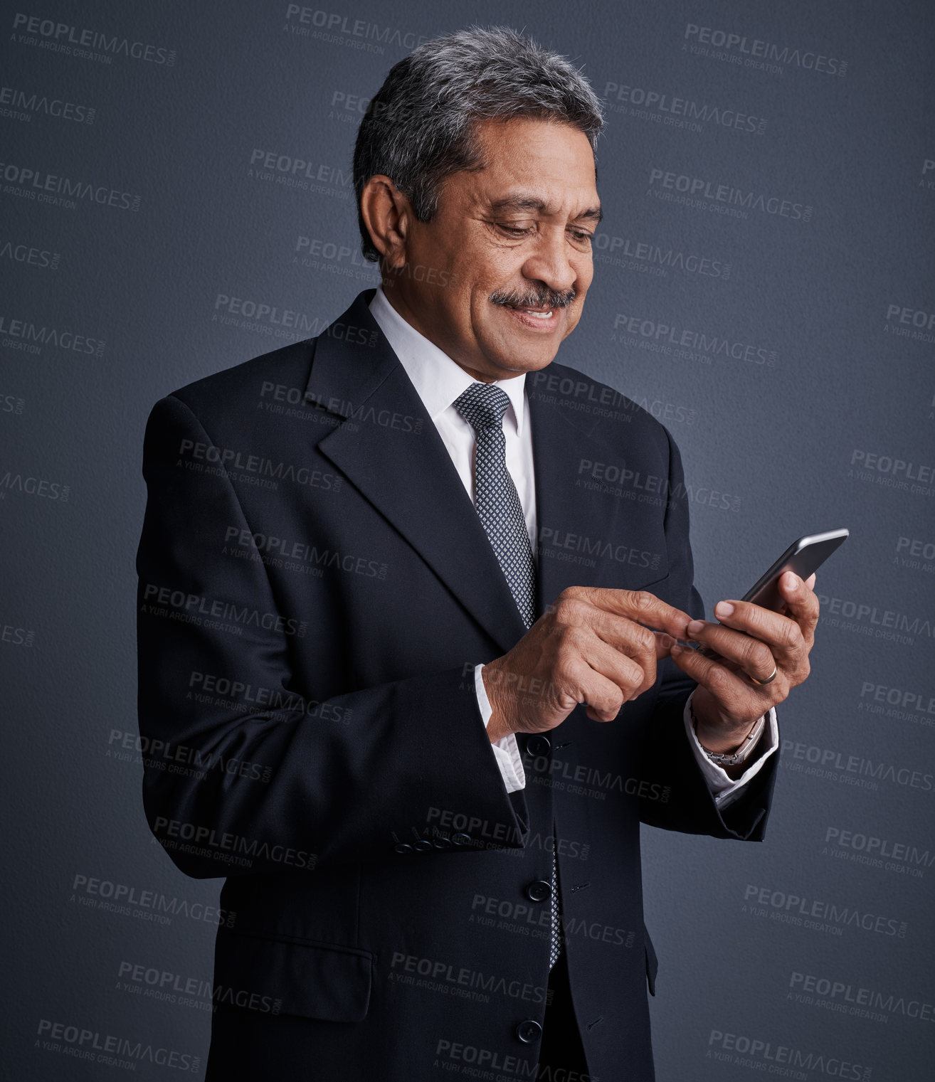 Buy stock photo Studio shot of a mature businessman using his cellphone