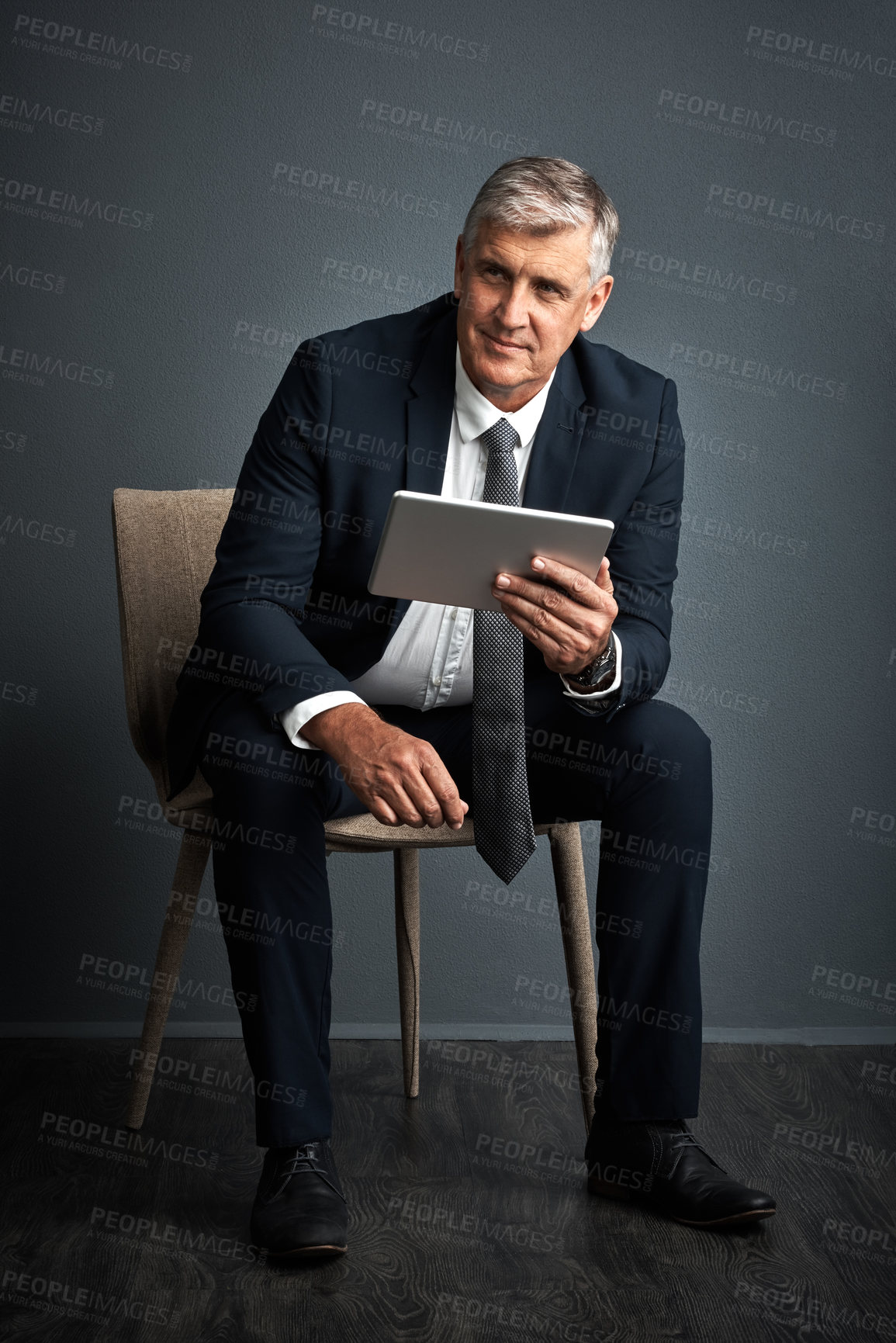 Buy stock photo Studio shot of a mature businessman using his digital tablet