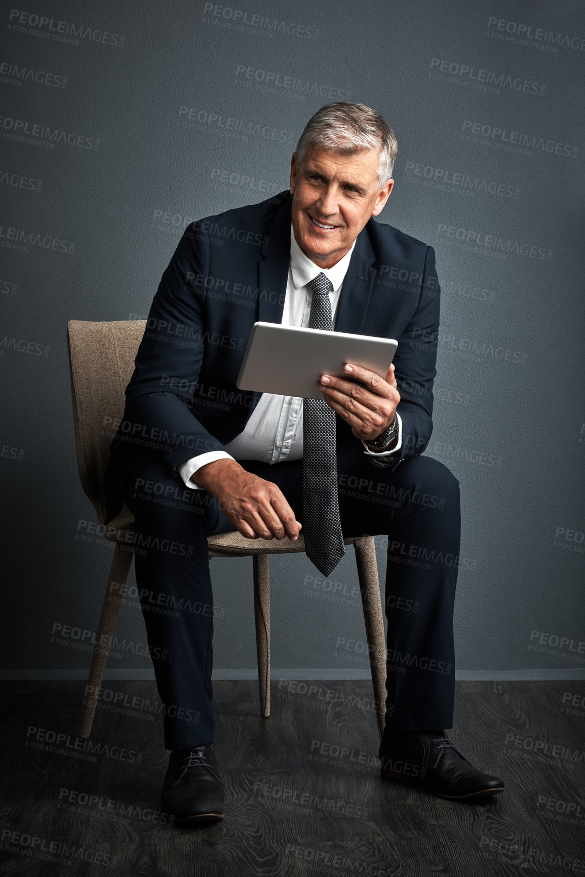 Buy stock photo Studio shot of a mature businessman using his digital tablet