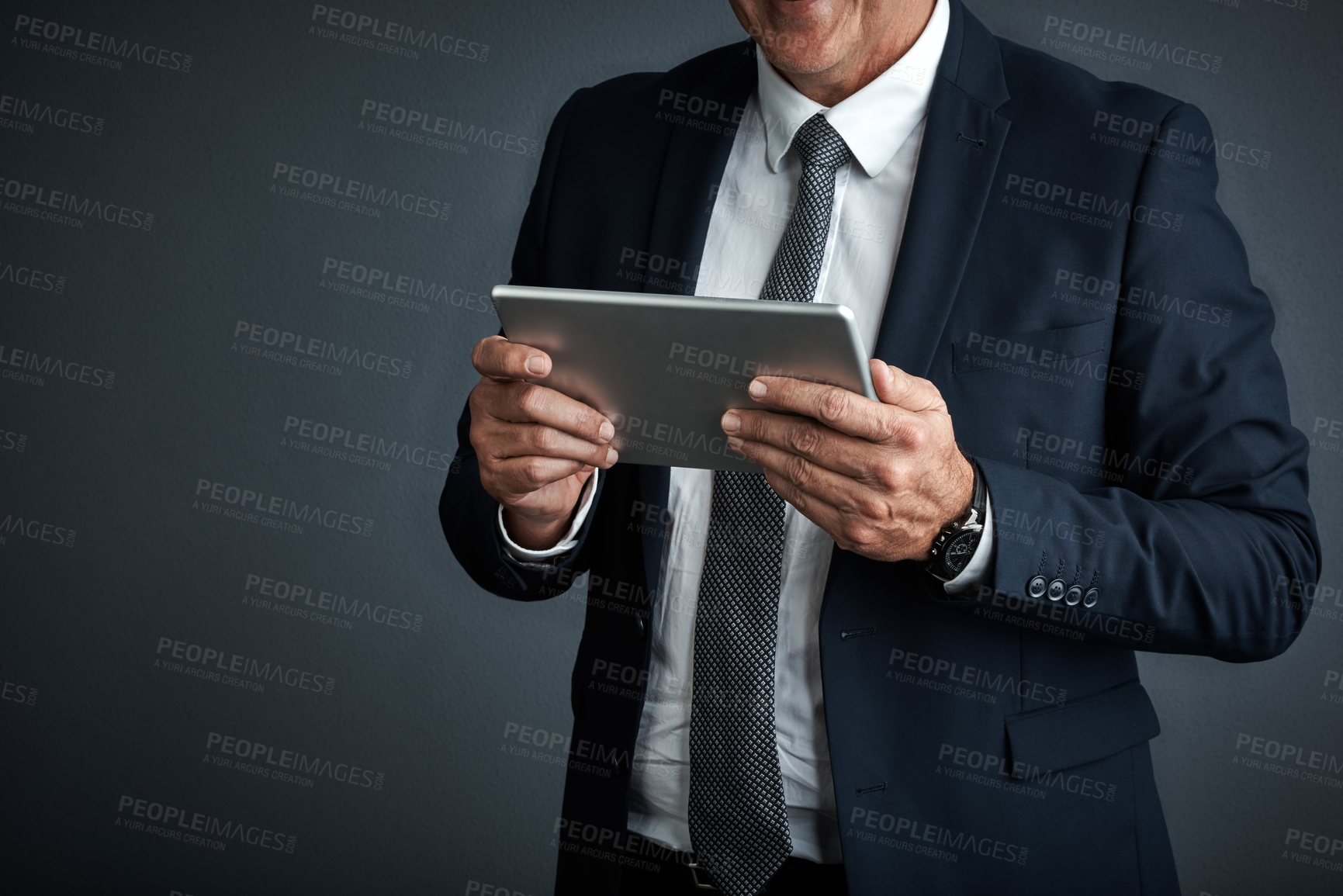 Buy stock photo Studio shot of a mature businessman using his digital tablet