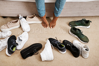 Buy stock photo Cropped shot of a woman trying on different pairs of shoes at home