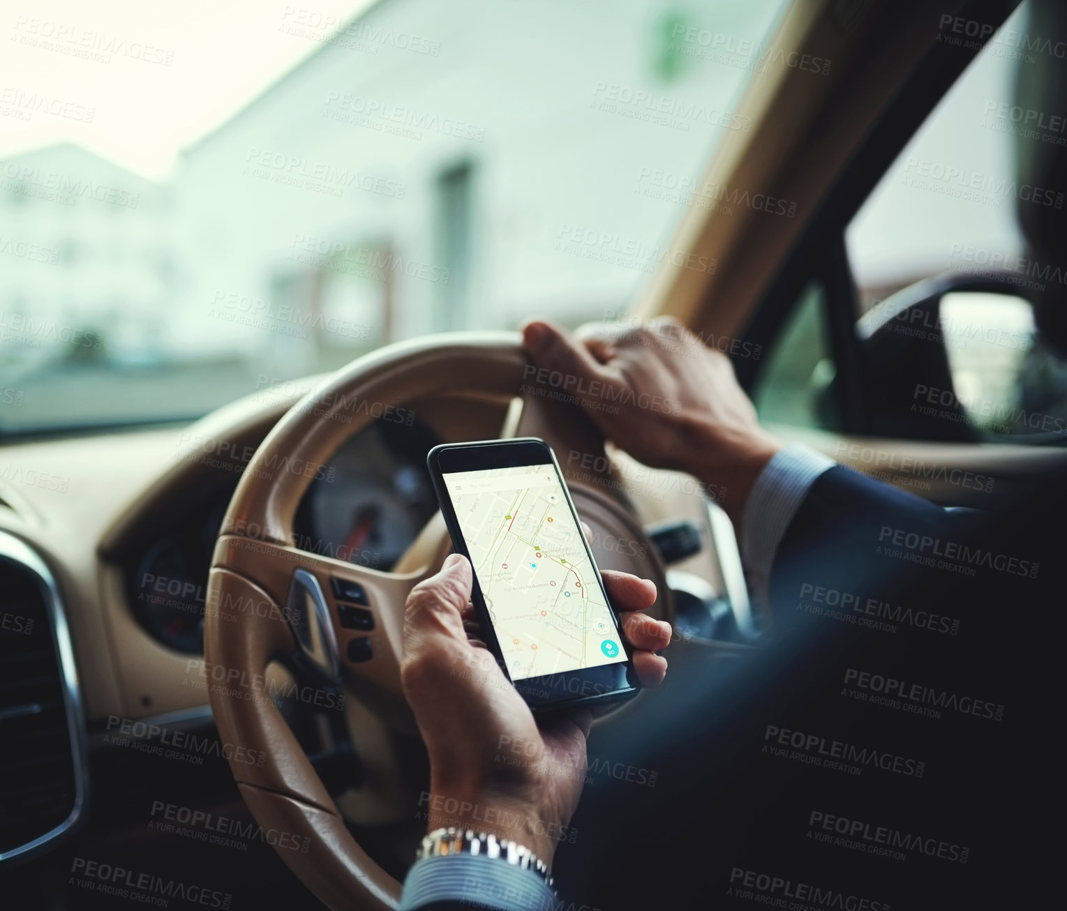 Buy stock photo Cropped shot of a businessman using his phone’s gps while driving a car