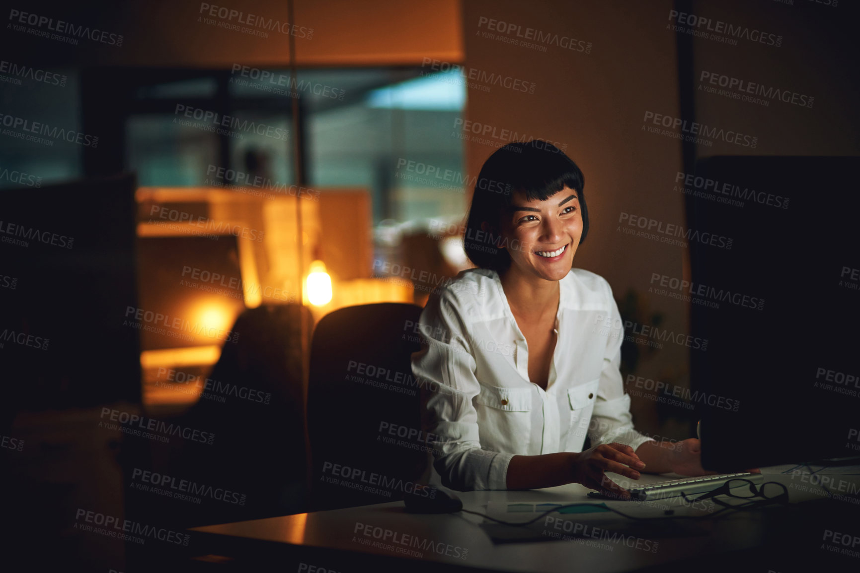 Buy stock photo Shot of a young businesswoman using a computer during a late night at work