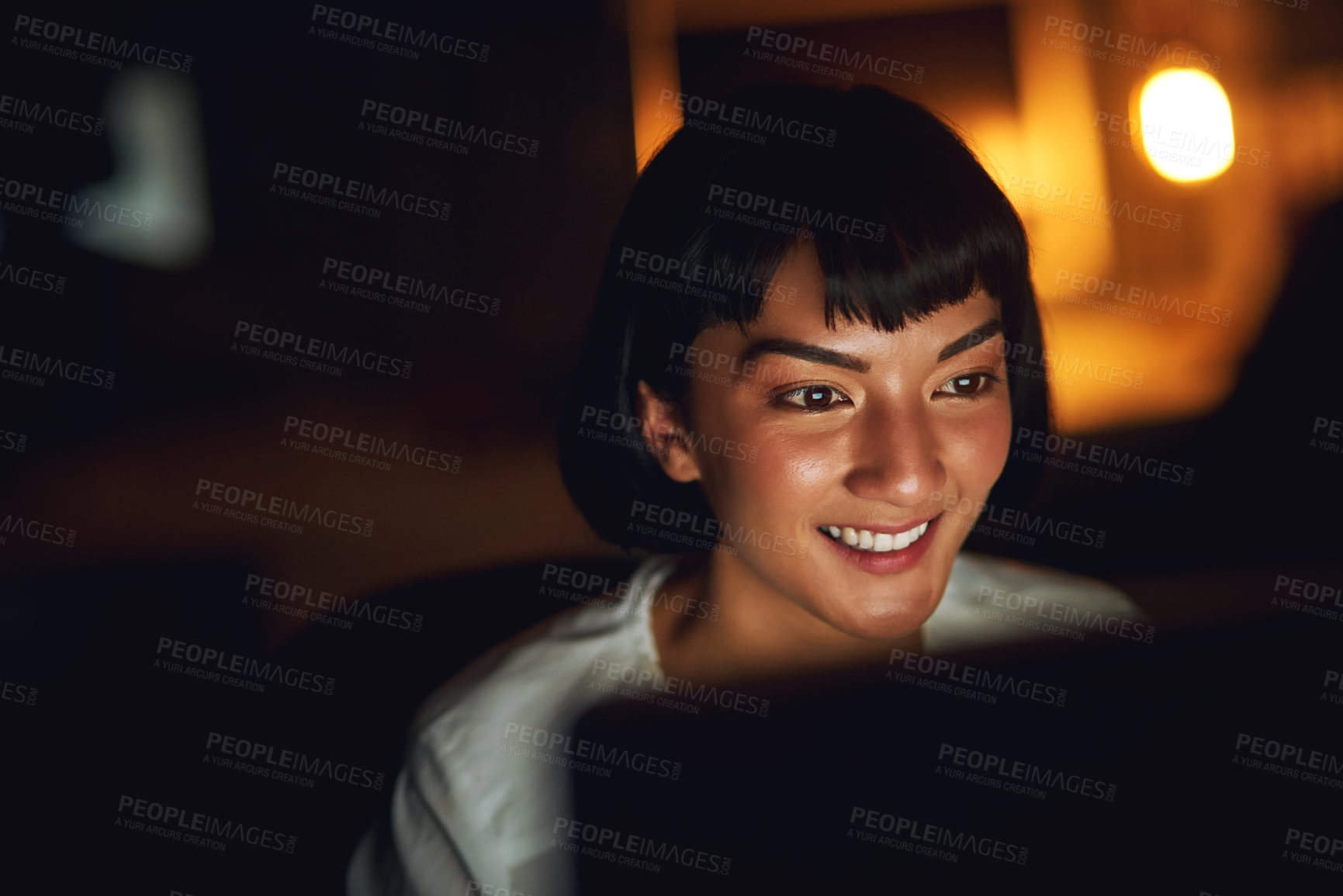 Buy stock photo Shot of a young businesswoman using a computer during a late night at work