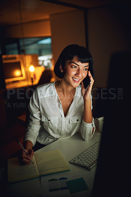 Buy stock photo Shot of a young businesswoman using a mobile phone and computer during a late night at work