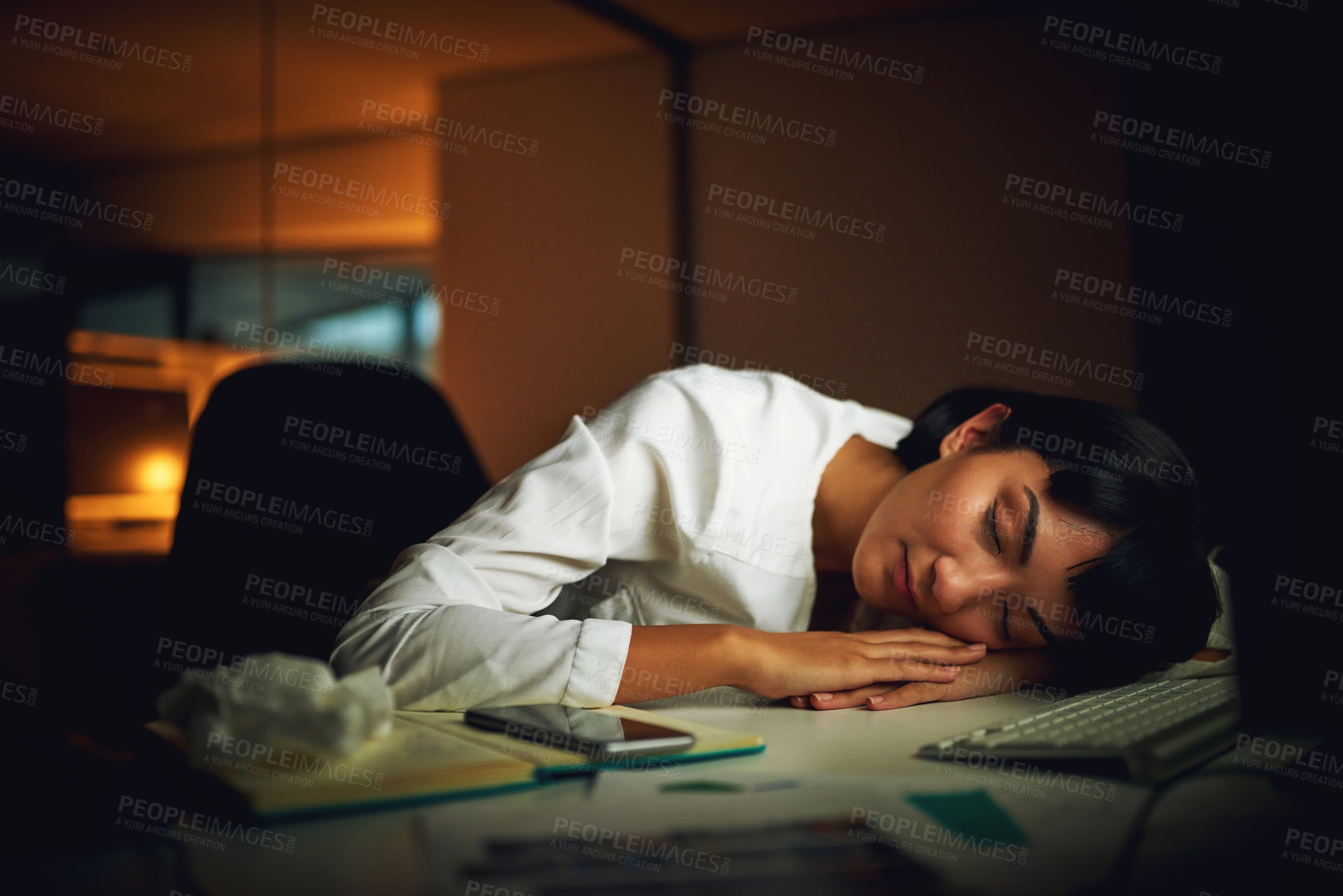 Buy stock photo Shot of a young businesswoman sleeping at her desk during a late night at work