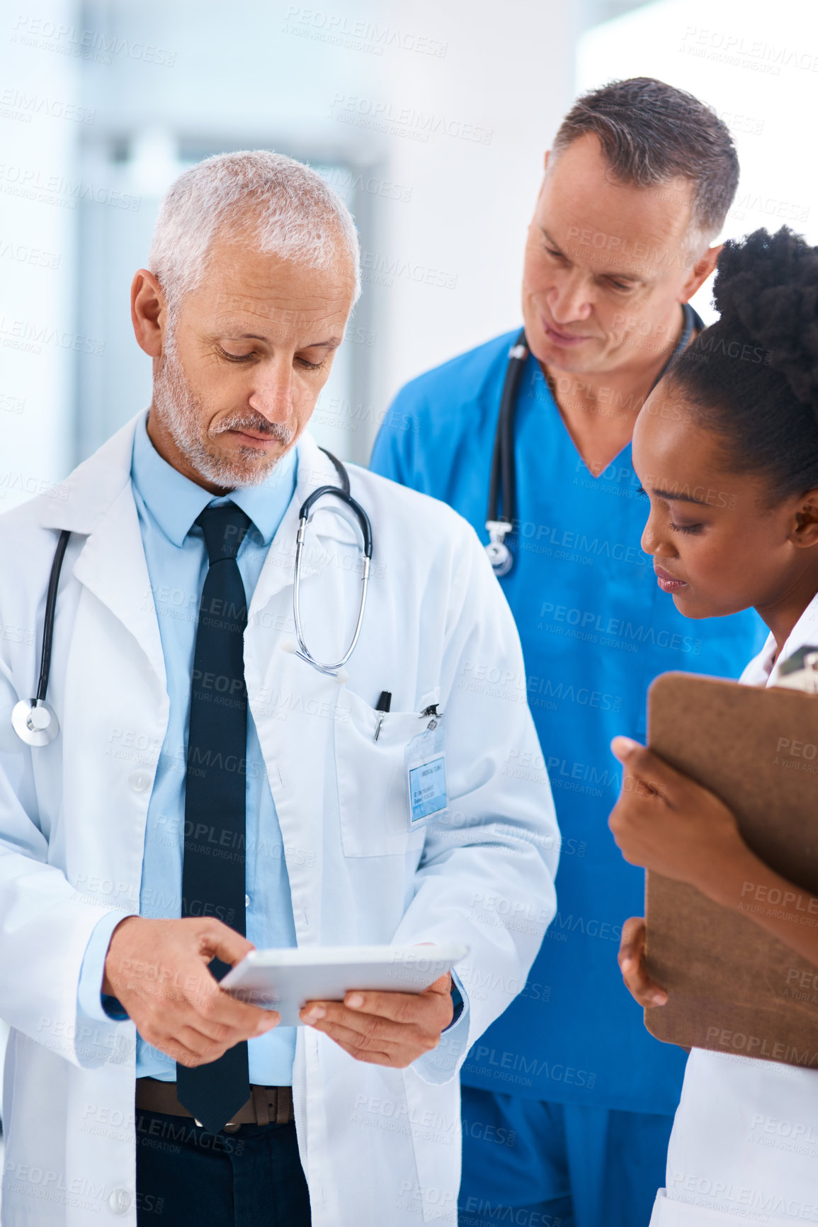 Buy stock photo Doctor, tablet and teamwork in a hospital with a mature manager with healthcare workers with tech. Clinic, cardiology research and digital report with conversation and collaboration with discussion