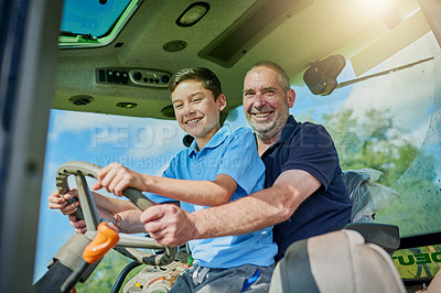 Buy stock photo Low angle portrait of a male farmer and his son inside the cockpit of a modern tractor