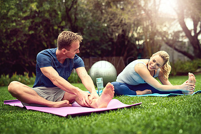 Buy stock photo Shot of a young couple exercising together outdoors