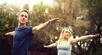 Buy stock photo Shot of a young couple practising yoga together outdoors