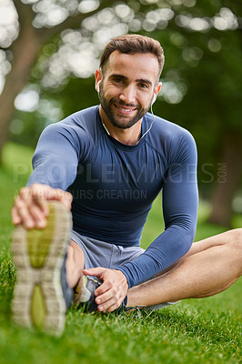 Buy stock photo Nature, portrait and man stretching legs with mobility for fitness, workout or running outdoor. Happy, earphones and male athlete with warm up exercise on grass for cardio, sports or training in park