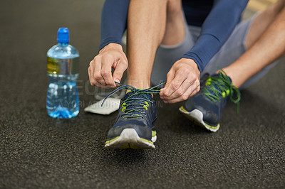 Buy stock photo Man, hands and tying shoes with water for fitness, workout preparation or training on floor at gym. Closeup, male person or runner with tie, sneakers or getting ready for running, cardio or health