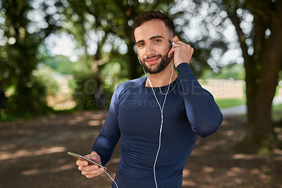 Buy stock photo Man, runner and phone with earphones in portrait at park, smile and exercise with audio streaming app. Person, happy and smartphone with online subscription for listening to music at training on path