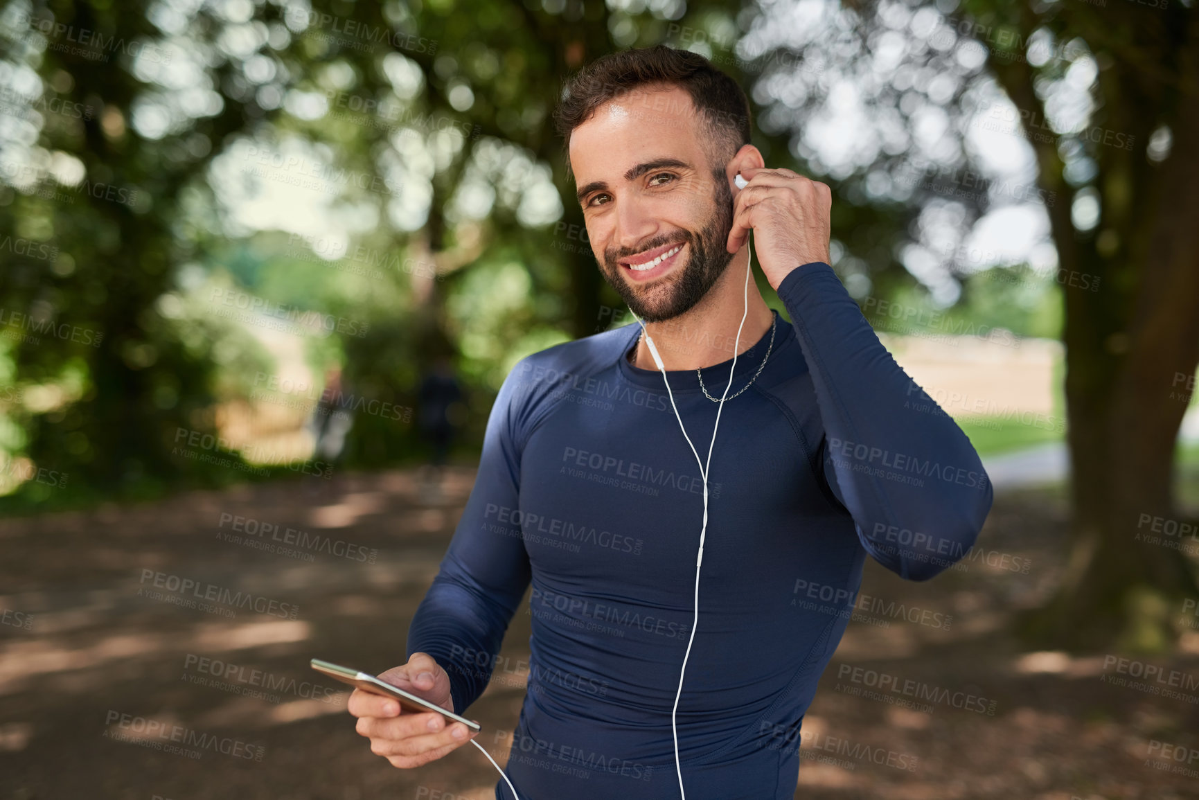 Buy stock photo Runner, man and phone with music in portrait at park, smile and exercise with audio streaming app. Person, happy and smartphone with online subscription to listen to playlist at training in Seattle