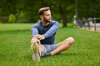 Buy stock photo Full length shot of a handsome young male runner warming up before his workout