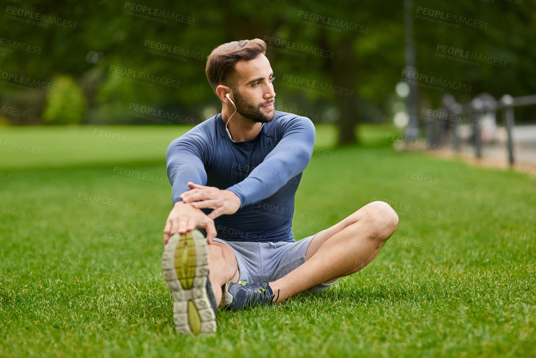 Buy stock photo Full length shot of a handsome young male runner warming up before his workout