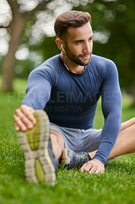 Buy stock photo Nature, health and man stretching legs with mobility for fitness, workout or running outdoor. Music, earphones and male athlete with warm up exercise on grass for cardio, sports or training in park.