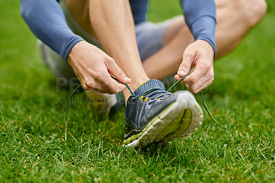 Buy stock photo Man, hands and tying shoes with grass field for fitness, workout preparation or outdoor training. Closeup, male person or runner with tie, sneakers or getting ready for running, cardio or exercise