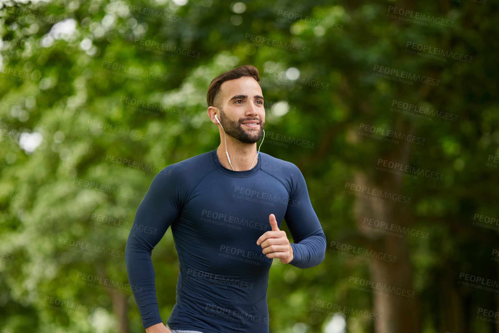 Buy stock photo Running, fitness and man in nature with earphones for listening to music, podcast or radio. Sports, workout and male athlete with audio tech for streaming cardio playlist for exercise at outdoor park