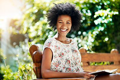 Buy stock photo Black woman, portrait and park with book for read, literature and learning outdoors in nature. Smile, afro and relax in spring for peace, knowledge or education for female person on weekend on bench
