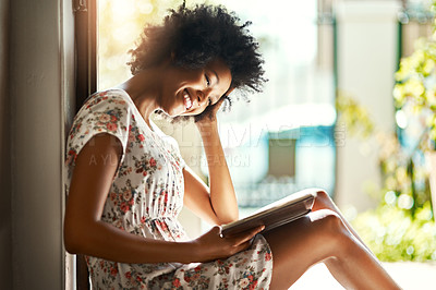 Buy stock photo Shot of a young woman relaxing with a book at home
