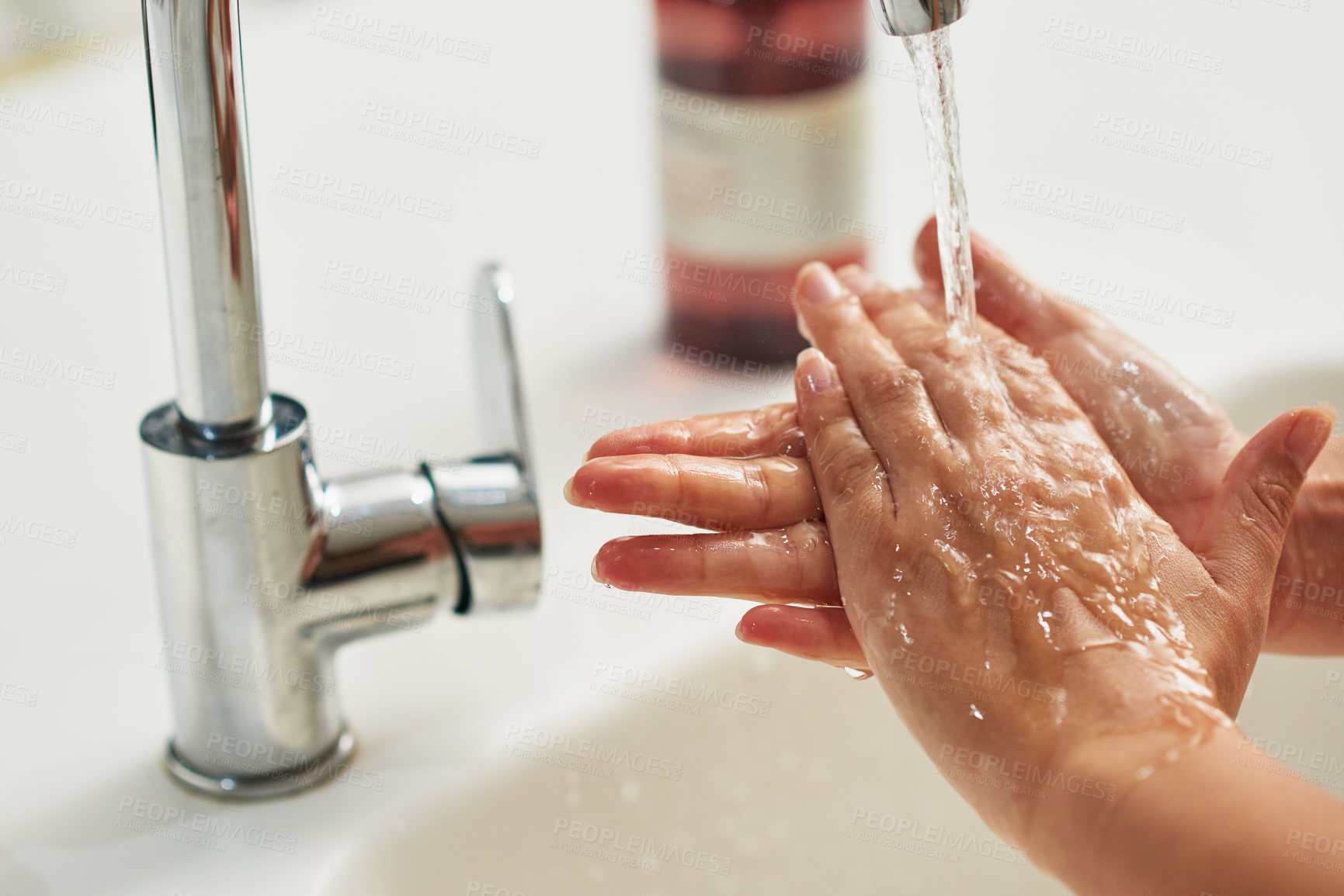 Buy stock photo Cropped shot of an unrecognizable woman washing her hands at a tap