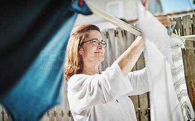 Buy stock photo Mature woman, clothesline and laundry outdoor with household domestic chores, spring cleaning and housekeeping. Hanging clothes, fabric or white cotton sheet, cleaner and housework in Australia