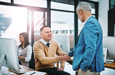 Buy stock photo Cropped shot of two handsome mature businessmen shaking hands in the office