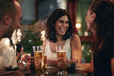 Buy stock photo Cropped shot of three friends having beers in a bar