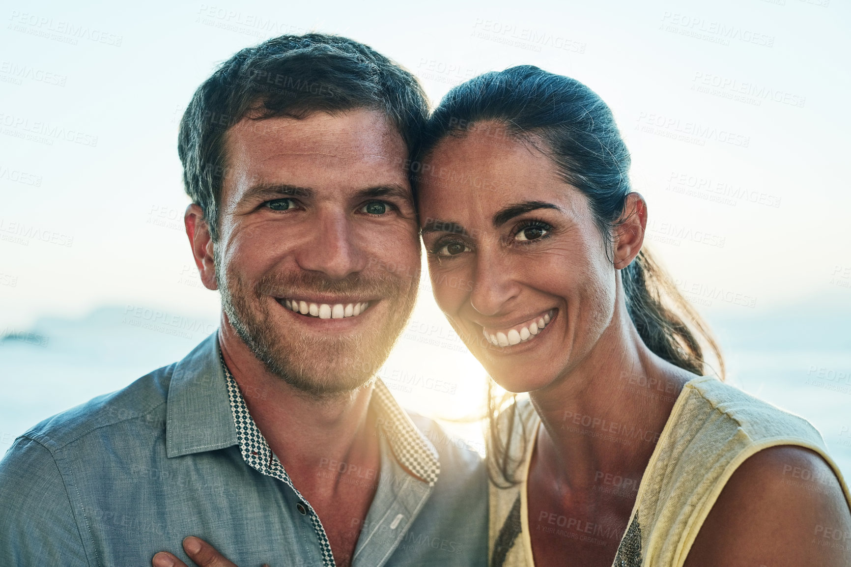 Buy stock photo Happy couple, portrait and hug by ocean on holiday, marriage commitment and travel to France. People, outdoor and embrace for support or security in relationship, romance and honeymoon weekend trip