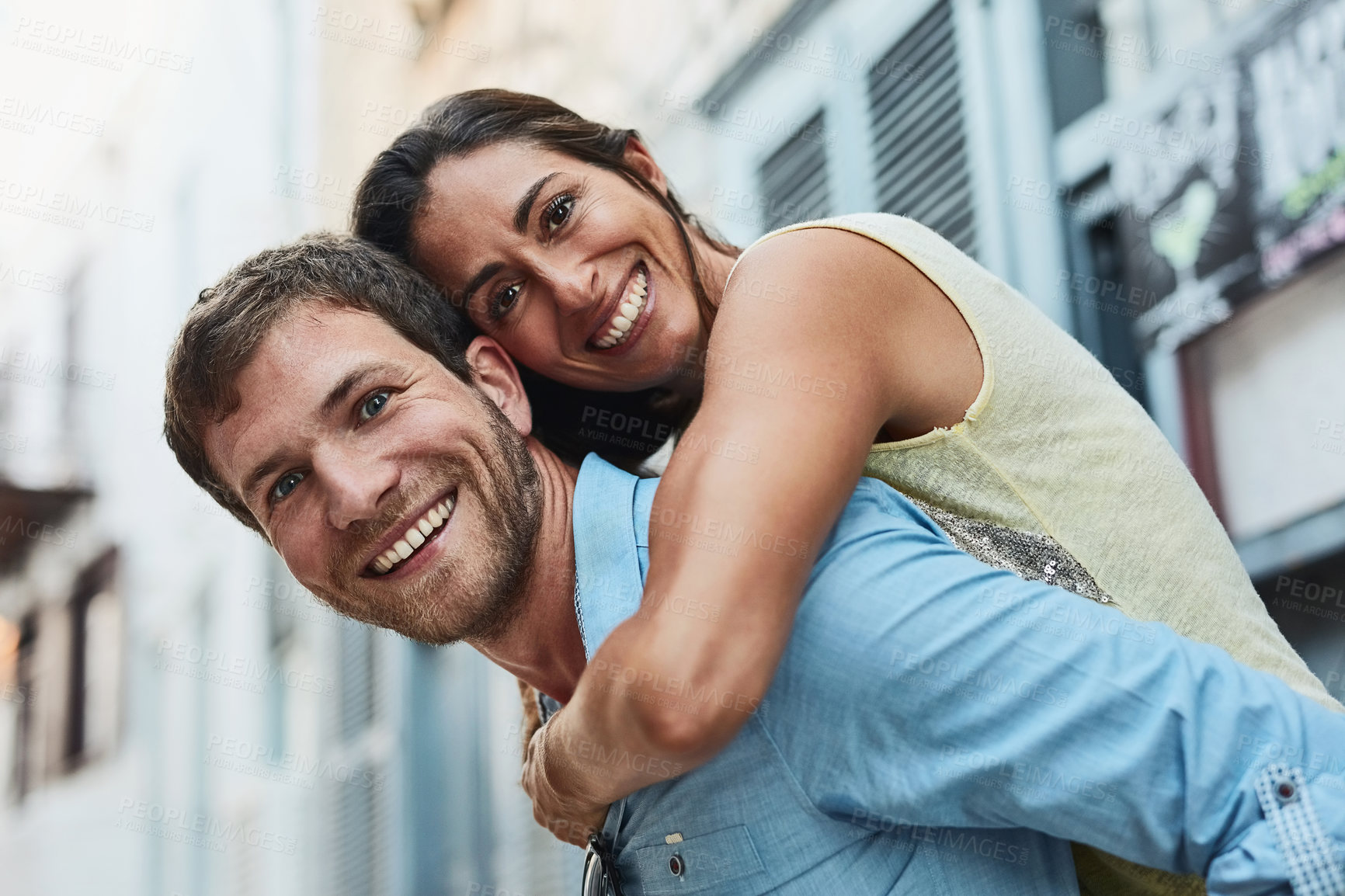 Buy stock photo Couple, portrait and piggyback in city on vacation, marriage commitment and travel to Greece. People, outdoor and support for security in relationship, adventure and play on honeymoon weekend trip